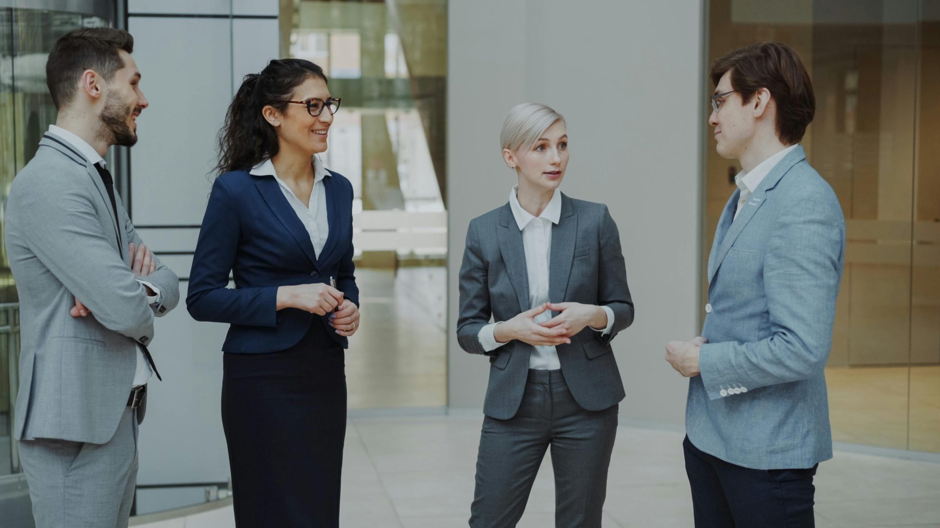 Group of diverse business professionals having a conversation in a modern office setting.