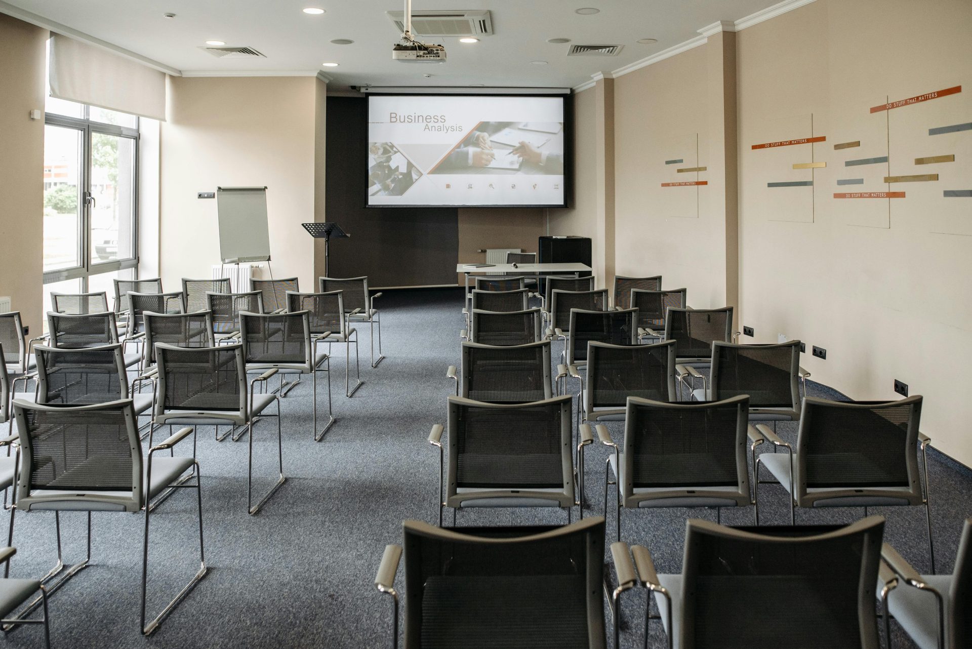 Empty conference room with chairs and a presentation screen setup for business meetings.