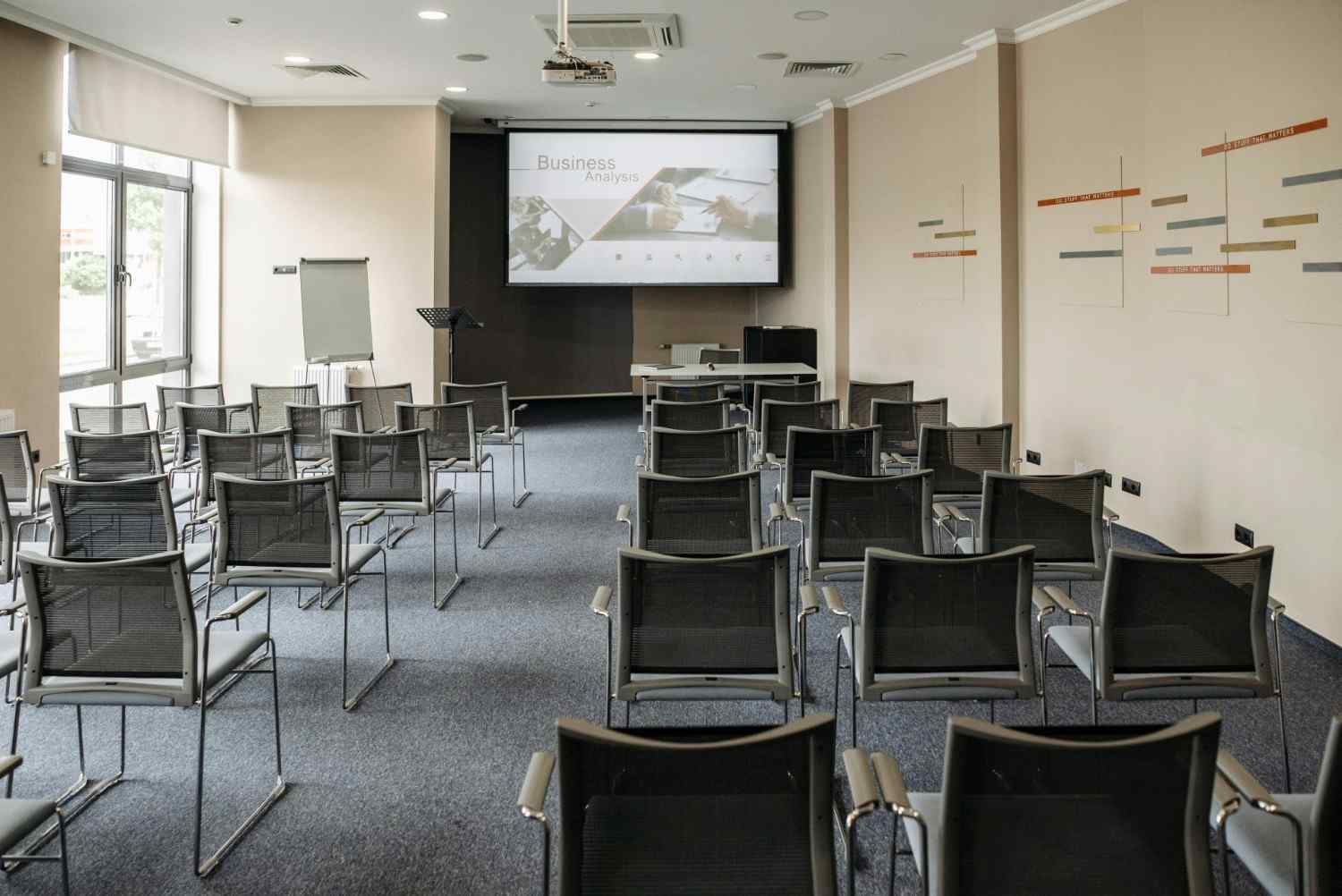 Empty conference room with chairs and a presentation screen setup for business meetings.